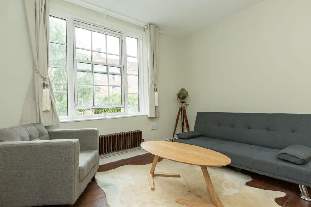 uma sala de estar com um sofá e uma mesa em Lovely 2 Bedroom Apartment in Waterloo em Londres