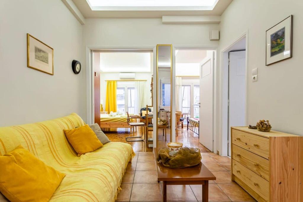 sala de estar con sofá amarillo y mesa en Athens Perfect Spot - Zografou Cozy Home, en Atenas