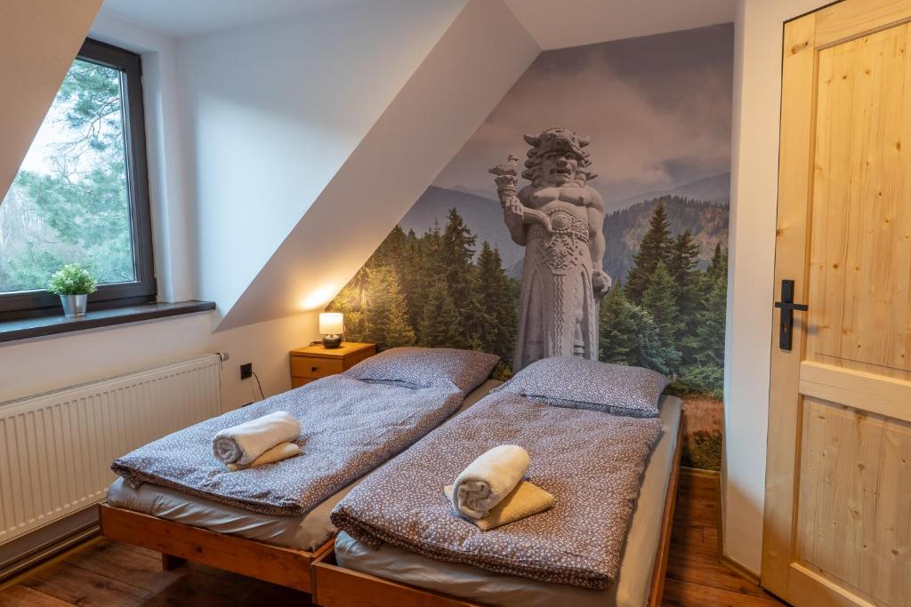 2 camas en una habitación con un mural en la pared en Koliba Pod Horů en Dolní Bečva