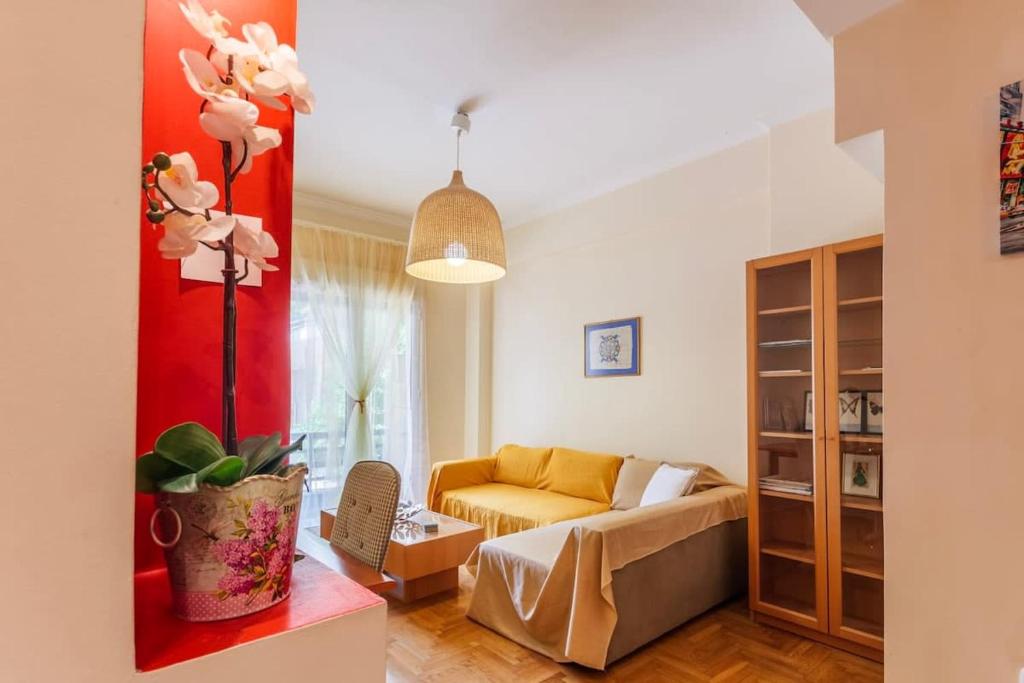 a living room with a yellow couch and a red wall at Athens Strawberry Hideaway - City Chic Retreat in Athens