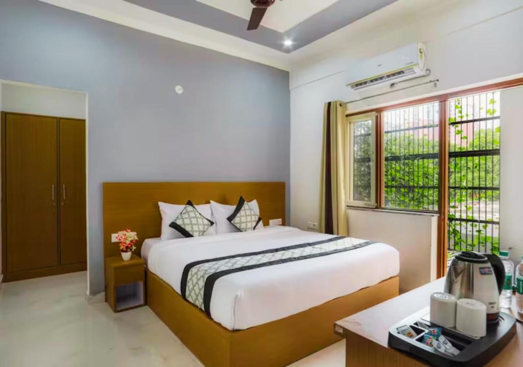 - une chambre avec un grand lit et une fenêtre dans l'établissement Blue Castle Inn, à Greater Noida