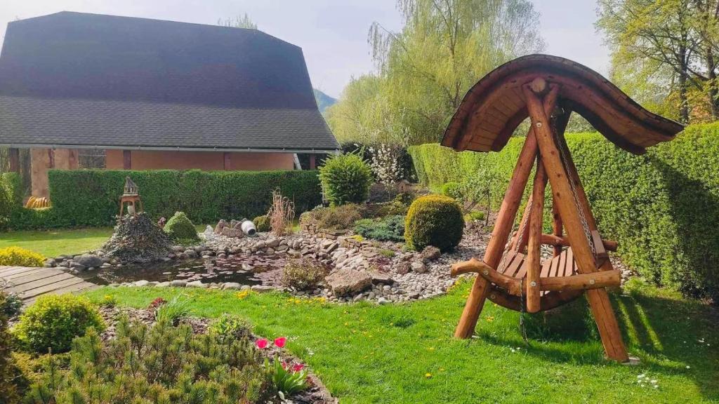 ogród z drewnianym parasolem w trawie w obiekcie Country House Liptov w mieście Svätý Kríž
