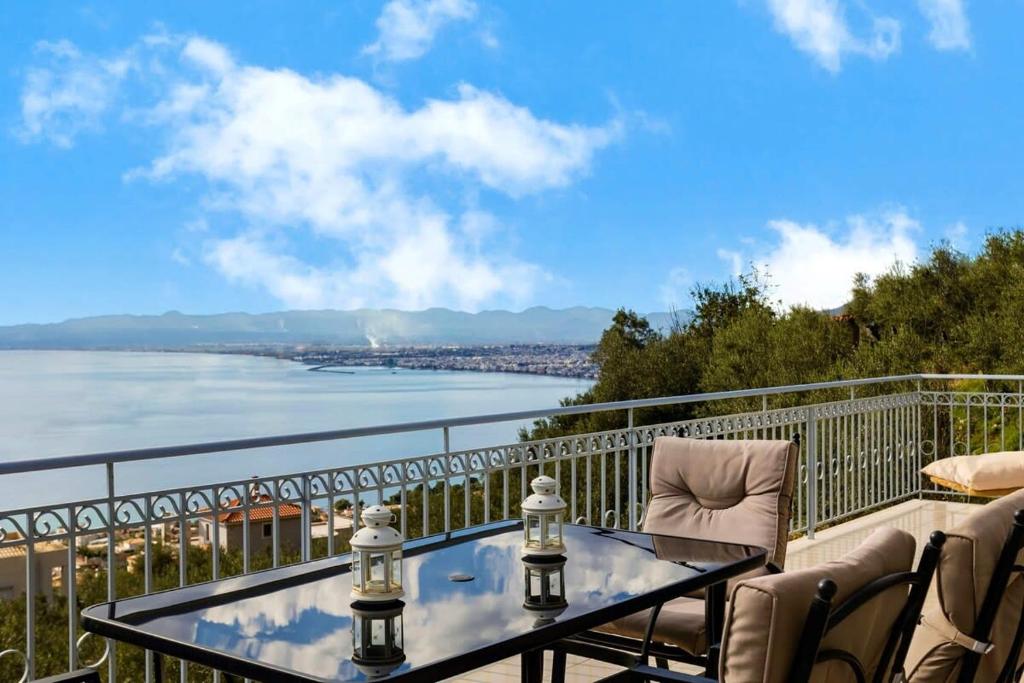 una mesa y sillas en un balcón con vistas al agua en Aigli Summer Getaway - Seaview Lux Retreat, en Verga Kalamata