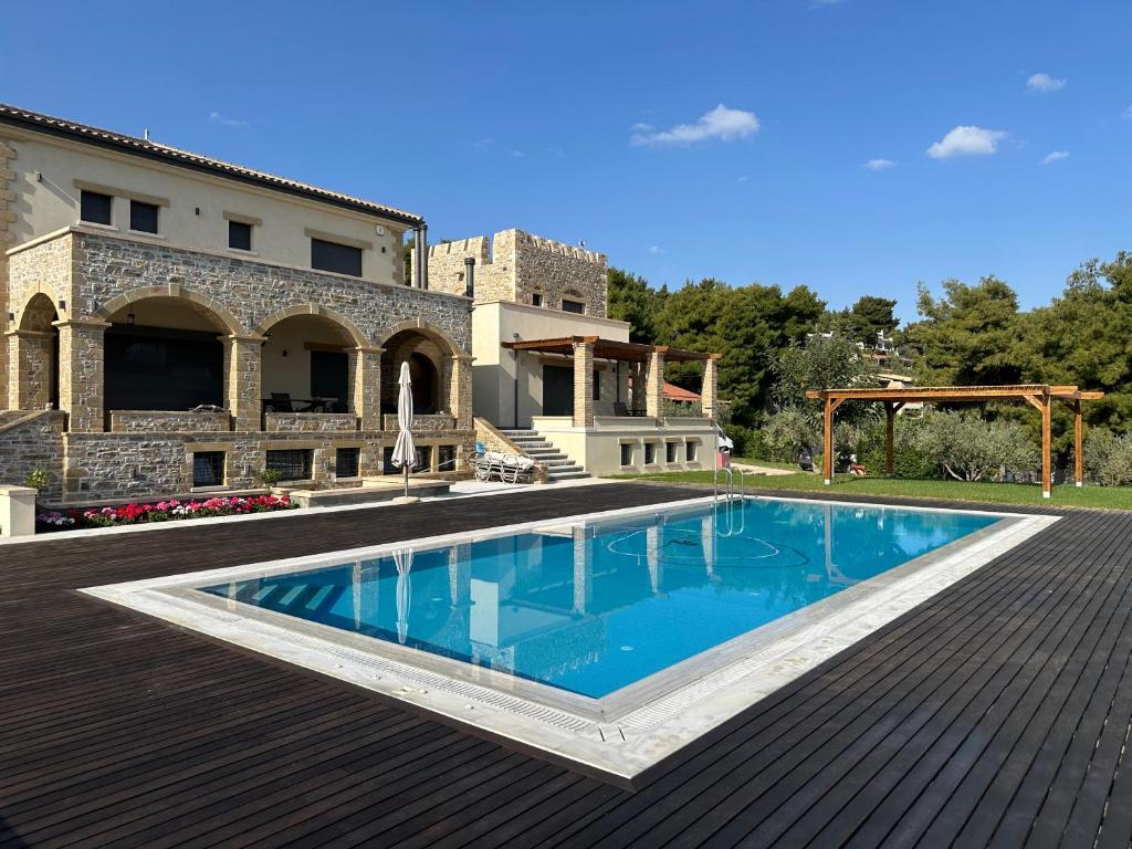 een zwembad op een terras met een huis bij Villa Kalamos / Sea View and Pool nearby Athens in Kalamos