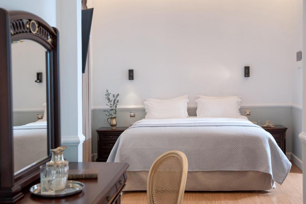 1 dormitorio con 1 cama grande y espejo en Acropolis Ami Boutique Hotel, en Atenas