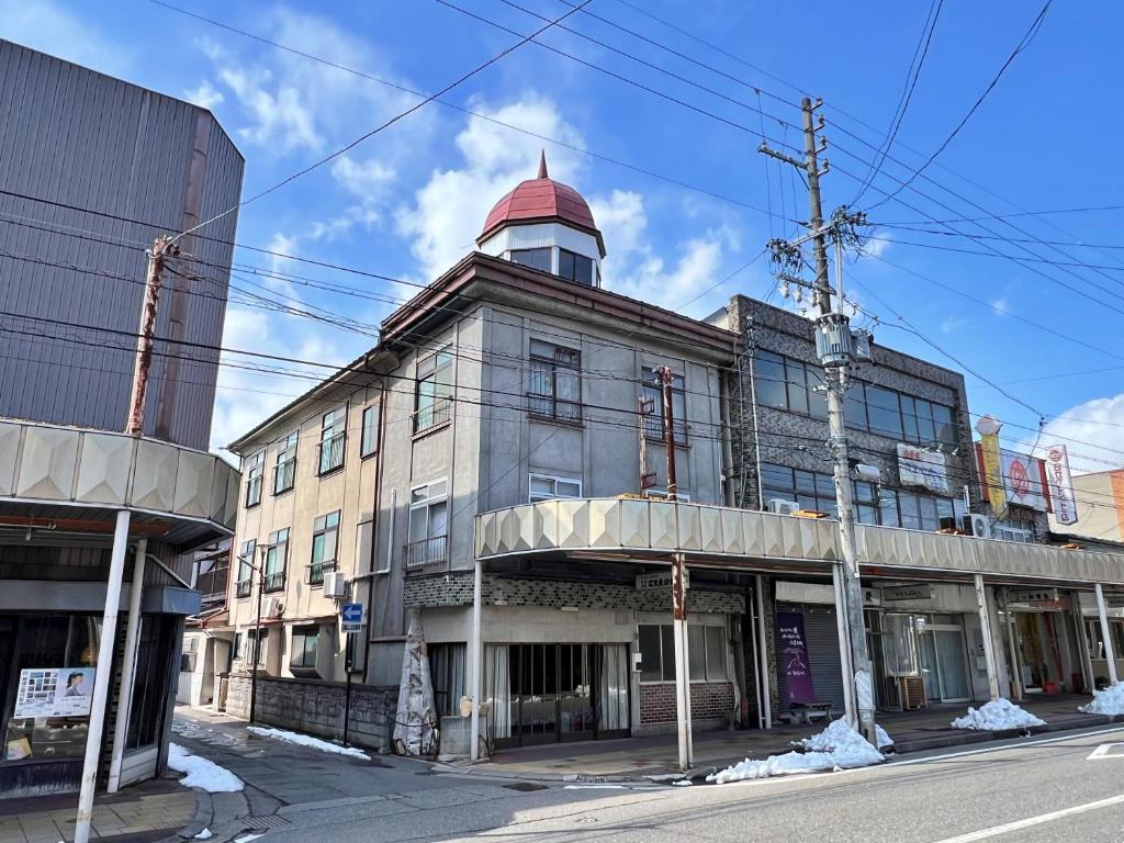 un antiguo edificio con una torre encima en 松葉屋ゲストハウス, en Ō-shinden