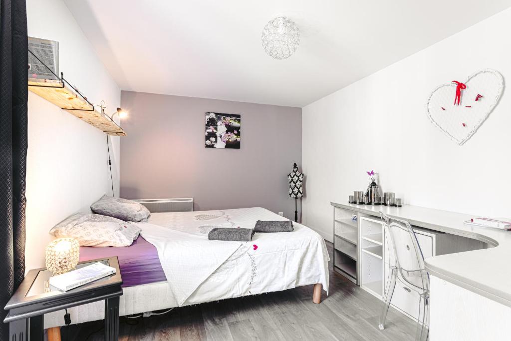 sypialnia z łóżkiem, biurkiem i umywalką w obiekcie Apart Sud Vendée,zen et confort w mieście Saint-Hilaire-des-Loges