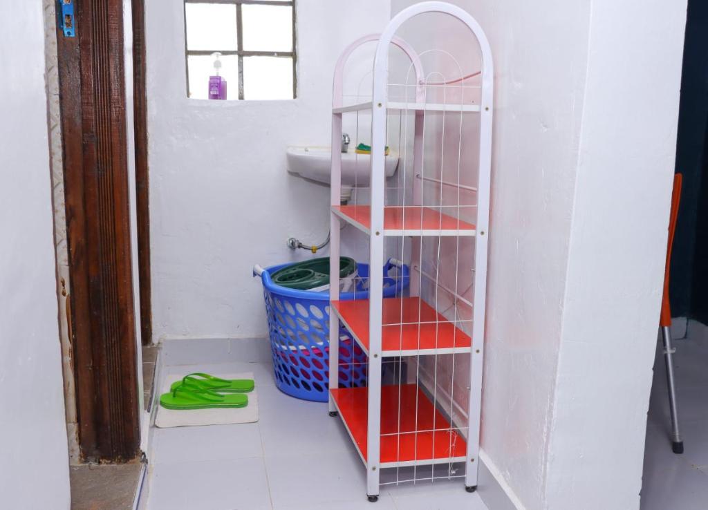 ein Badezimmer mit einem weißen Regal und einem Waschbecken in der Unterkunft Lulu Stays 1 Bedroom in Nyahururu