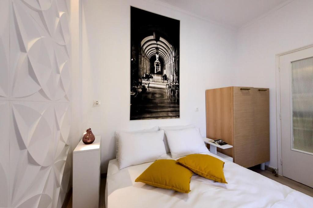 sypialnia z łóżkiem z 2 żółtymi poduszkami w obiekcie City Skyloft - Top location & Private Roof Garden w Kalamácie