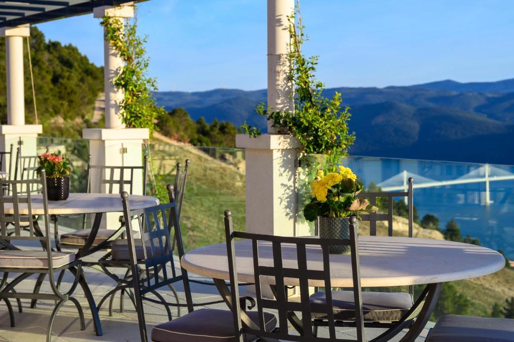 a table and chairs with flowers on a patio at Winery Rizman B&B in Slivno Ravno