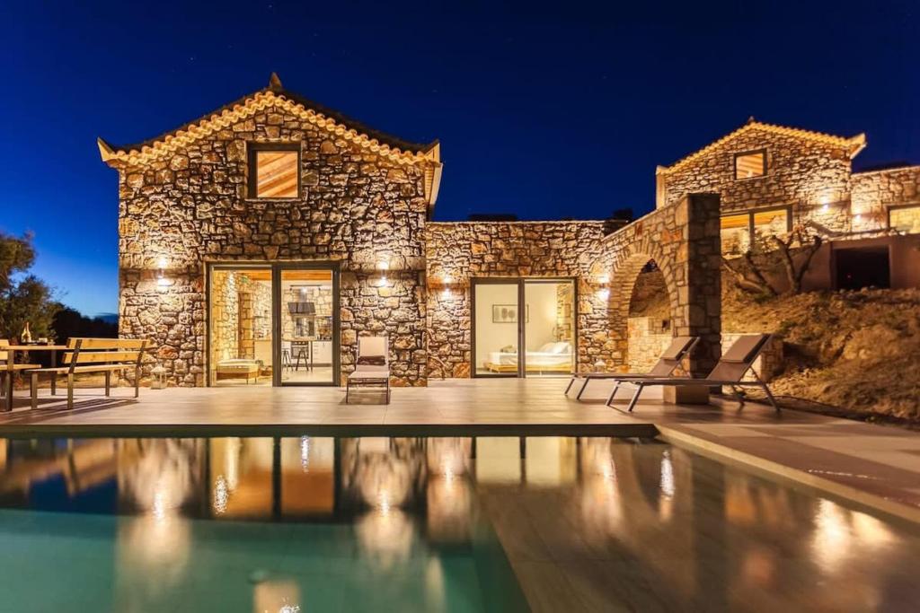 ein Steinhaus mit Pool in der Nacht in der Unterkunft Gerakada Exclusive-Seaview Villa with Private Pool in Koroni