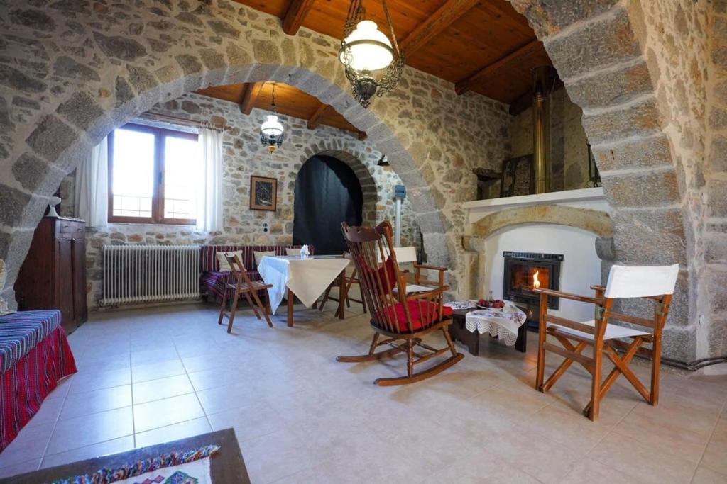a living room with a table and a fireplace at Unwind and Relax at the Vilaeti 1871 Retreat in Agios Konstantinos