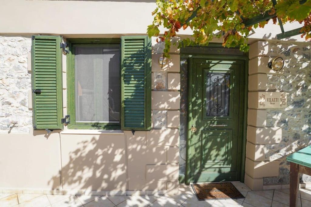 a green door and windows on a building at Vilaeti Havgas Getaway - Cretan Cozy Home in Agios Konstantinos