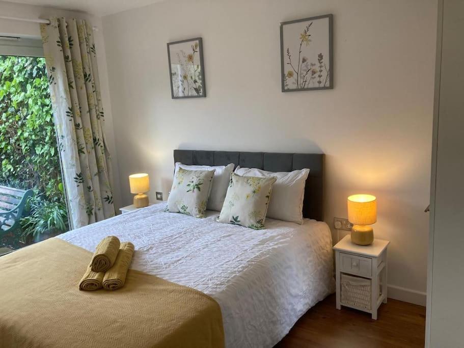 a bedroom with a bed with two lamps and a window at Park Cottage - Cosy 1 bedroom in Spinney Hill