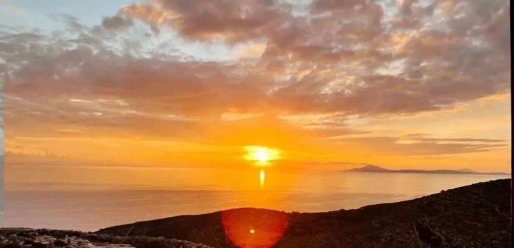 una puesta de sol sobre el océano con el sol en el cielo en Folegandros Enchanting Cycladic Home Sunset Views en Áno Meriá