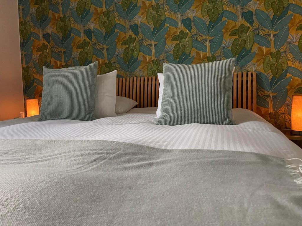 Una cama con dos almohadas encima. en La Majolique, en Namur