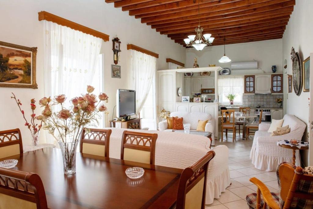 a living room with a wooden table and a dining room at Neoclassical Splendor Unique Experience in Leros in Panteli