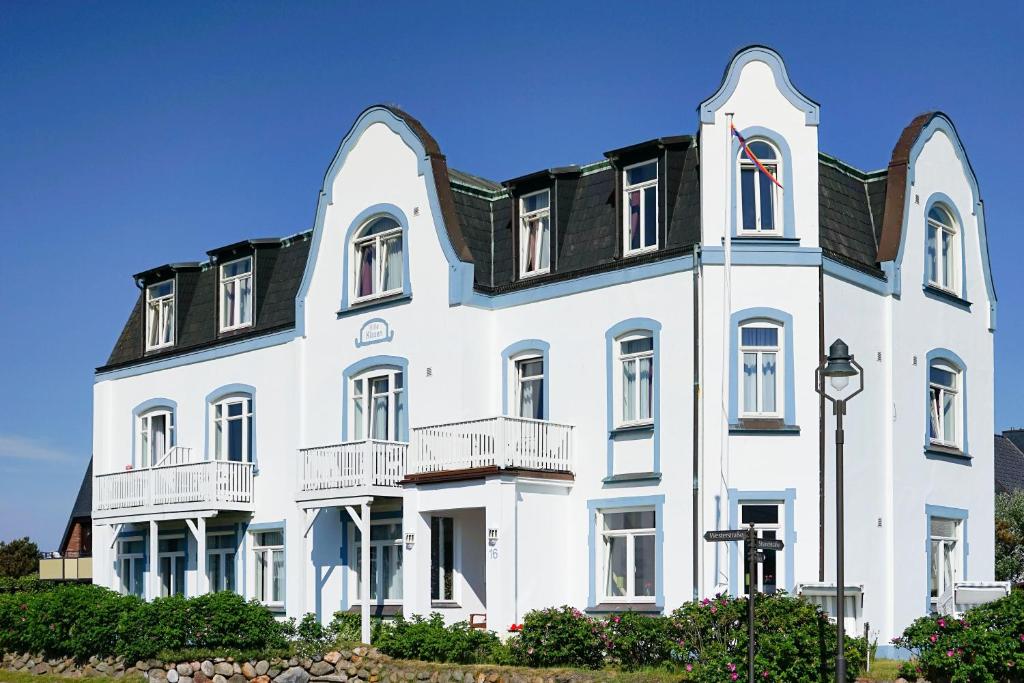 ein großes weißes Gebäude mit schwarzem Dach in der Unterkunft Hotel Villa Klasen in Wenningstedt-Braderup