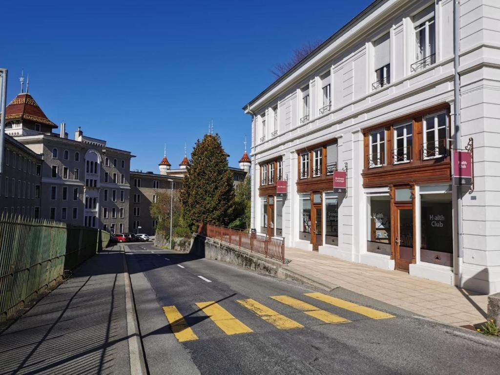eine leere Straße in einer Stadt mit Gebäuden in der Unterkunft Beaumane Rooms in Caux sur Montreux