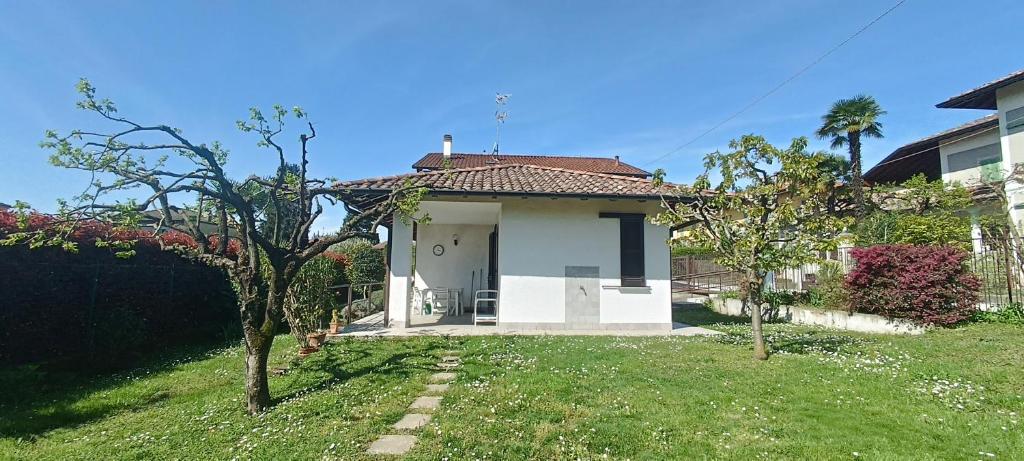 a small white house with a grass yard at La Casa di Rina in Angera