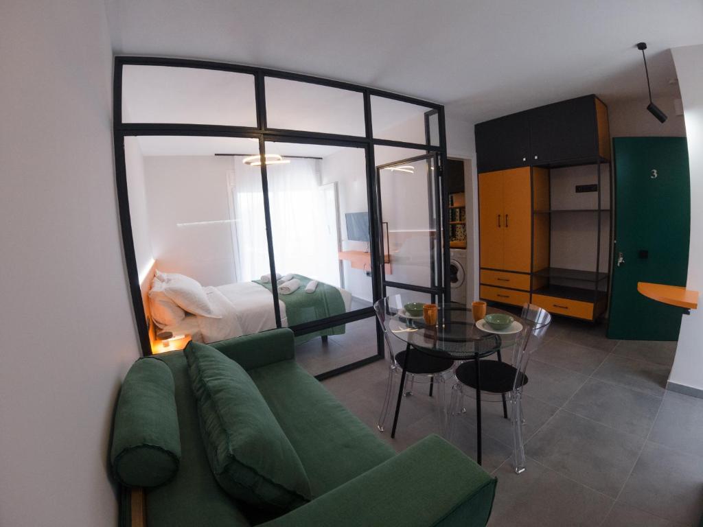 ein Wohnzimmer mit einem grünen Sofa und ein Schlafzimmer in der Unterkunft IOANNINA SUITES in Ioannina