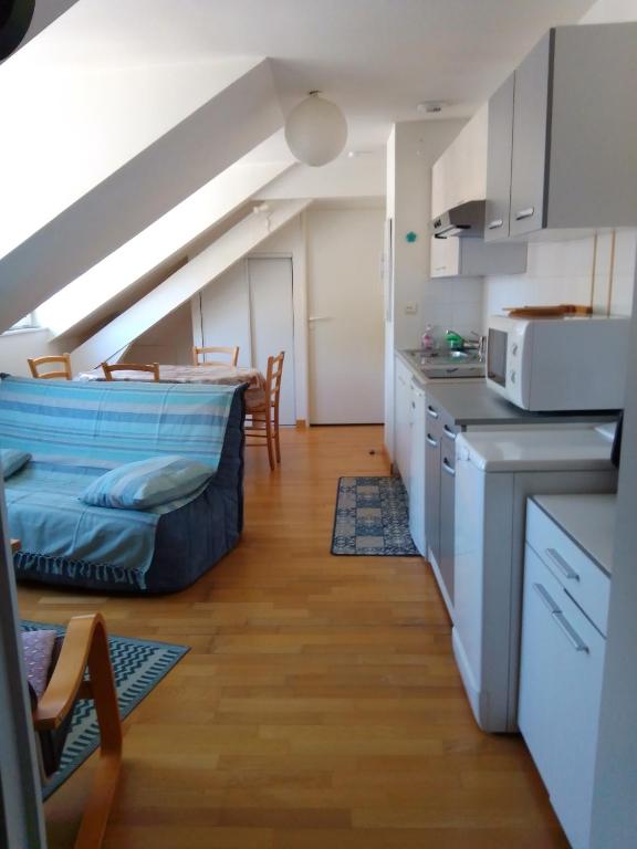 eine Küche mit einem Bett in der Mitte eines Zimmers in der Unterkunft Appartement au coeur de Luchon in Luchon
