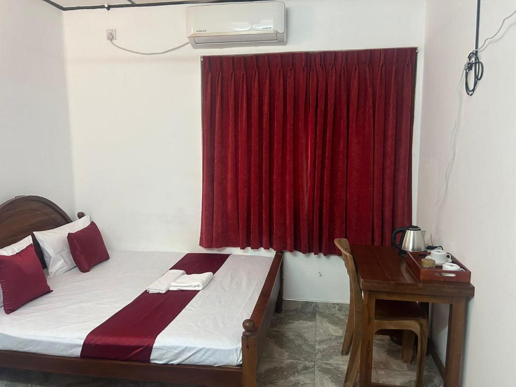 una camera con letto e finestra rossa di MercuryFM 109 Guest House - Jaffna Temple road 77 a Jaffna