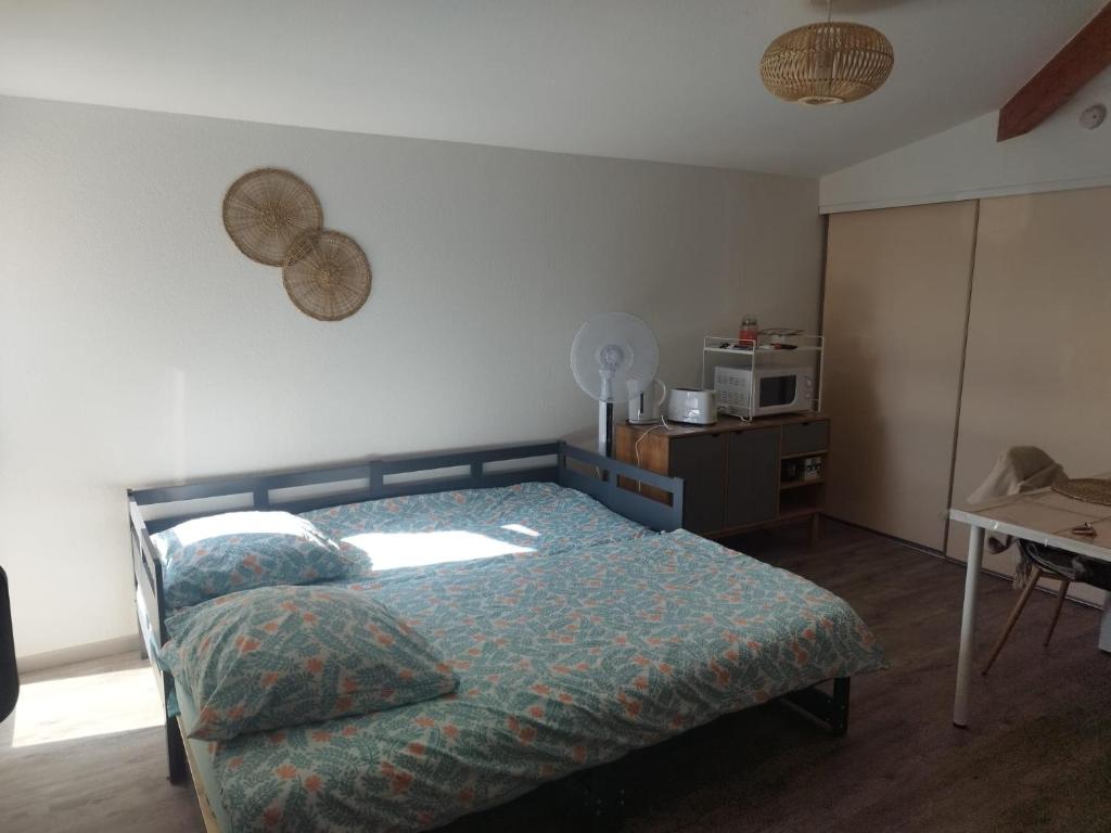 - une chambre avec un lit et une table avec un four micro-ondes dans l'établissement studio en intramuros, à Avignon