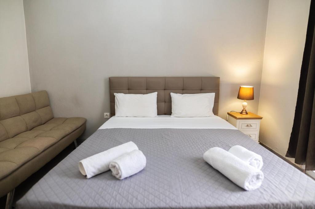 una camera da letto con un letto e due asciugamani di HILI RESORT LUXURIOUS SEASIDE APARTMENT a Alexandroupoli
