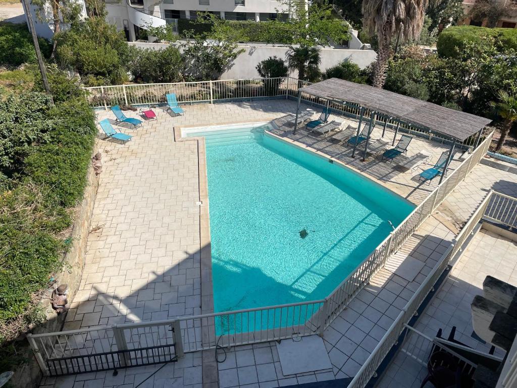 una vista dall'alto di una grande piscina con sedie a sdraio di La Tour Génoise - Climatisé avec piscine partagée a LʼÎle-Rousse