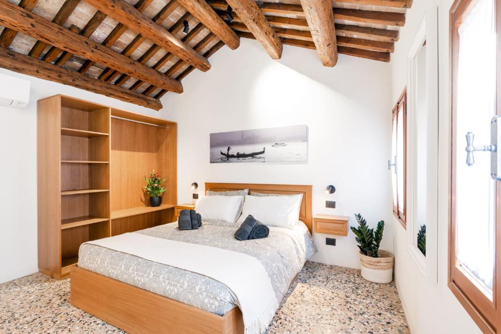 ヴェネツィアにある5 minuti da Rialto, intera palazzina Venezianaの木製の天井の部屋にあるベッドのある寝室