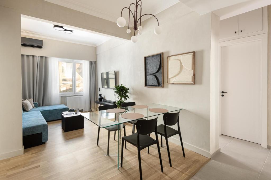 a dining room and living room with a table and chairs at Colors Hotel Athens in Athens