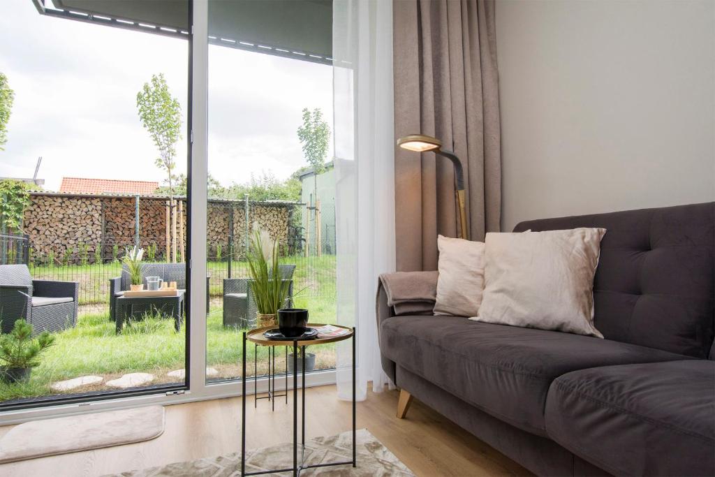 a living room with a couch and a large window at Golden Sand - Baltic Line in Gdańsk