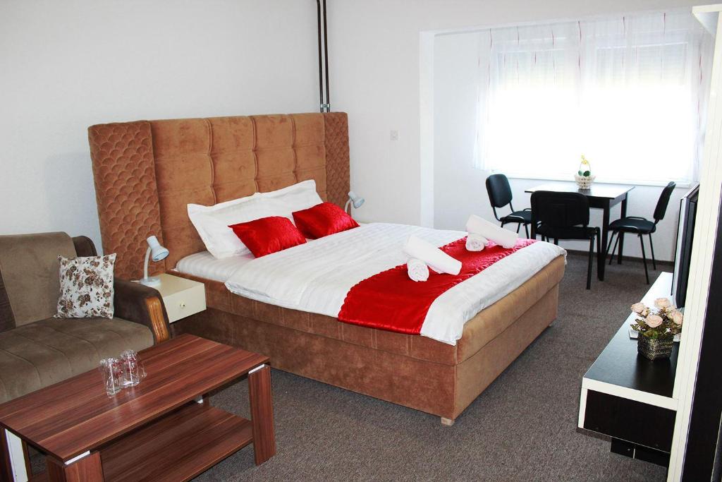1 dormitorio con 1 cama con 2 toallas rosas en Hostel Imran Zenica, en Zenica