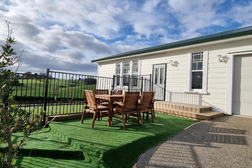 eine Terrasse mit einem Tisch und Stühlen auf einem Rasen in der Unterkunft Sunshine Studio in Hamilton