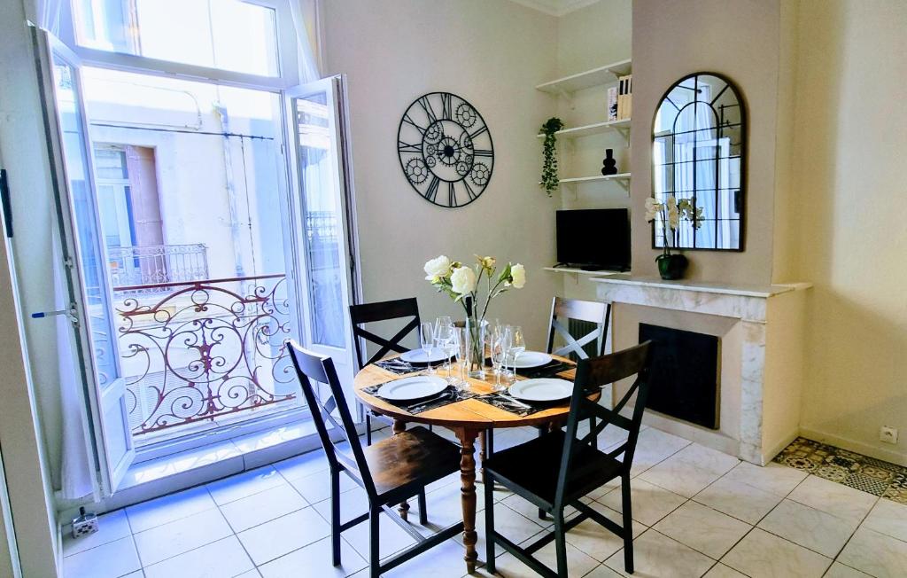 une salle à manger avec une table, des chaises et une cheminée dans l'établissement LE MONTMORENCY 35 Authentique Centre Historique Climatisation, à Sète