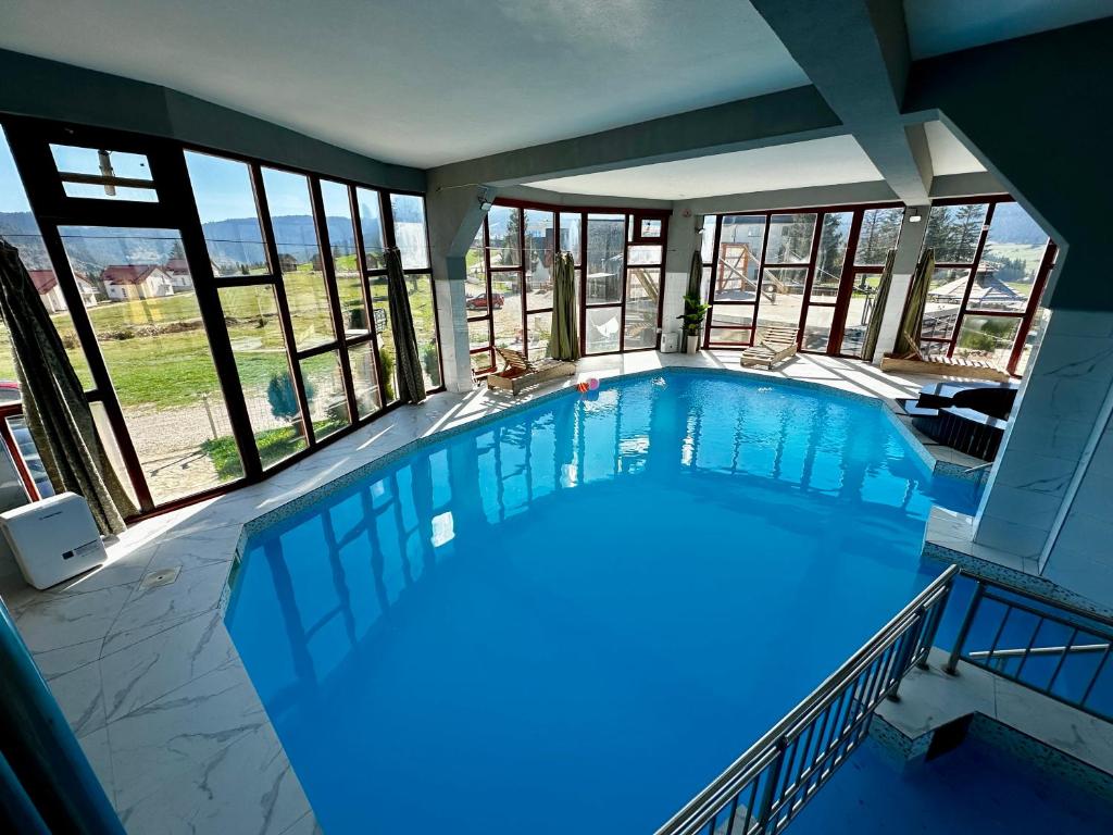 a large swimming pool in a building with windows at Vila Vlasic Odmor wellness & spa in Vlasic