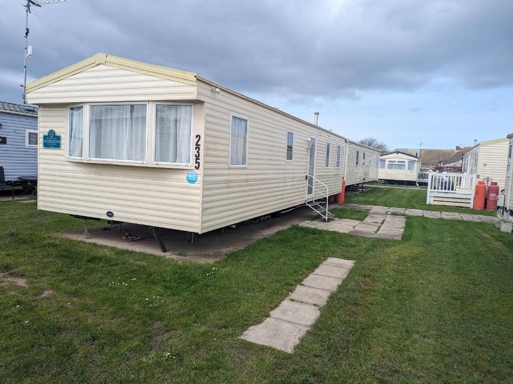 a mobile home is parked in a yard at 3 Bedroom Caravan, Sleeps 8 Lyons Lido Beach in Prestatyn