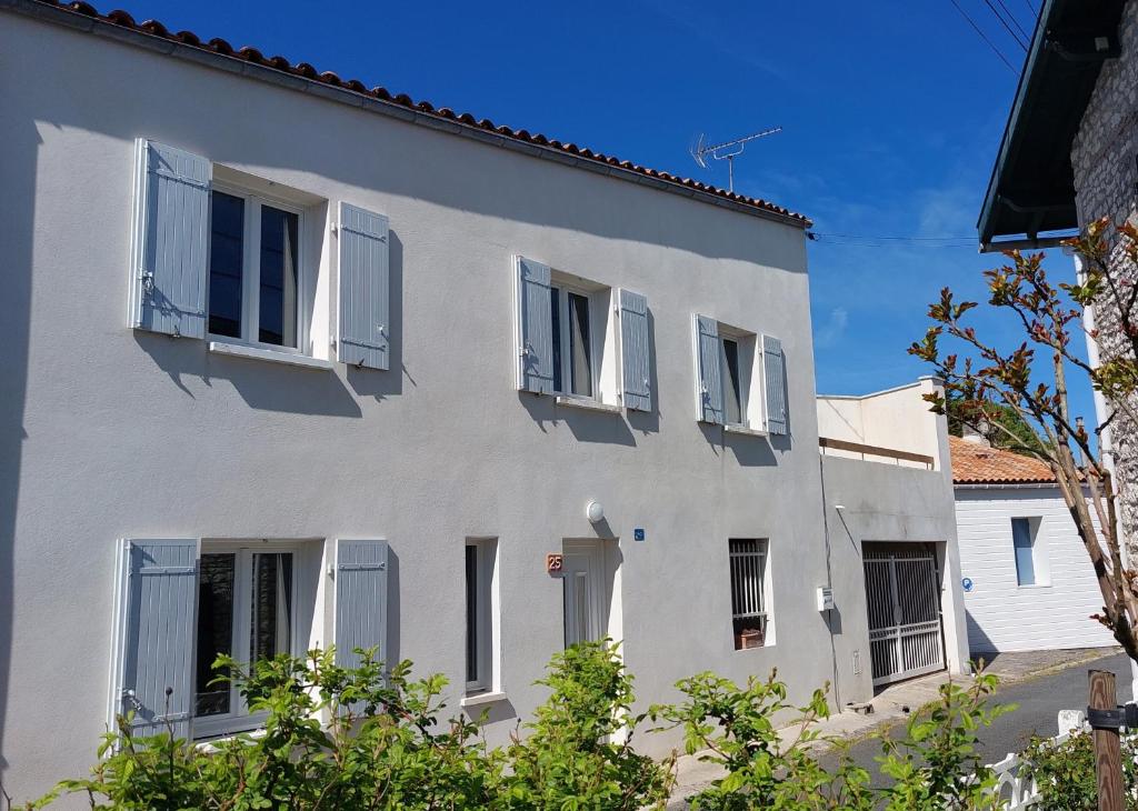 - un bâtiment blanc avec volets bleus dans l'établissement Maison au coeur de Meschers - proche des plages, à Meschers-sur-Gironde
