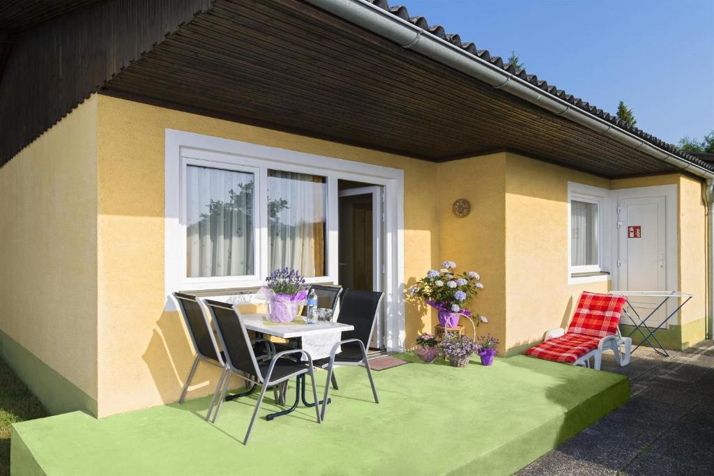 a patio with a table and chairs in front of a house at Ferienhäuser Angela in Unternarrach