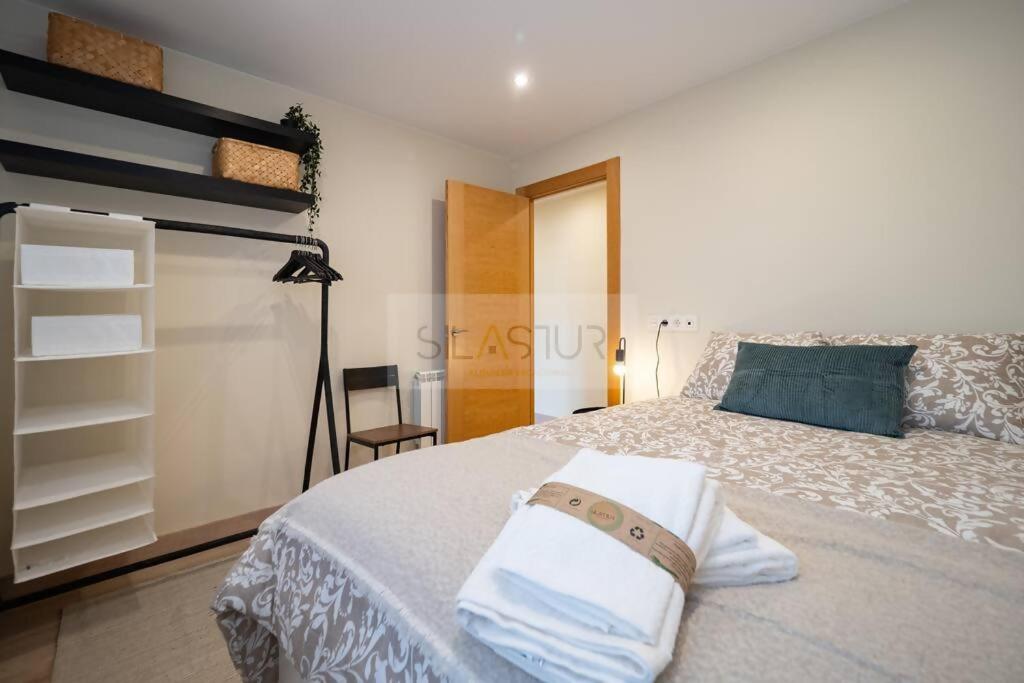um quarto com uma cama com uma almofada azul em Montes Suites em Gijón