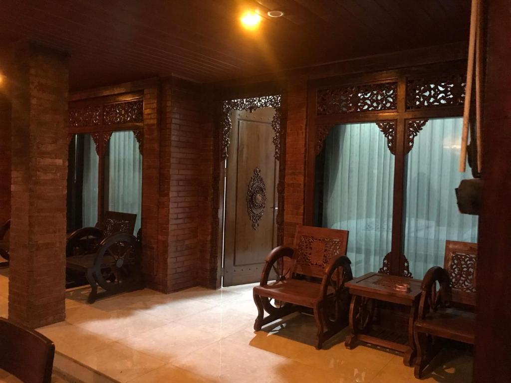 a living room with chairs and a door and windows at Mbah Oden Homestay Borobudur in Mendut