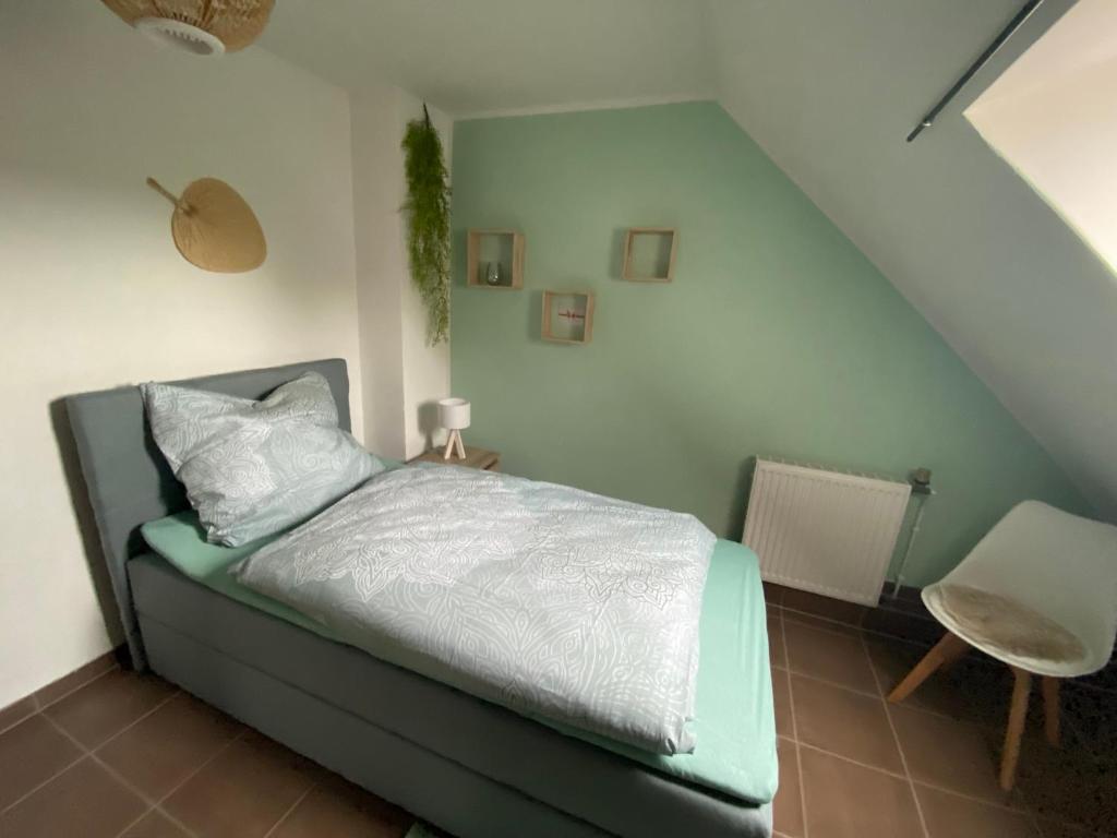 a bedroom with a bed and a chair at Einzelzimmer Nr. 4 in Kleve in Kleve