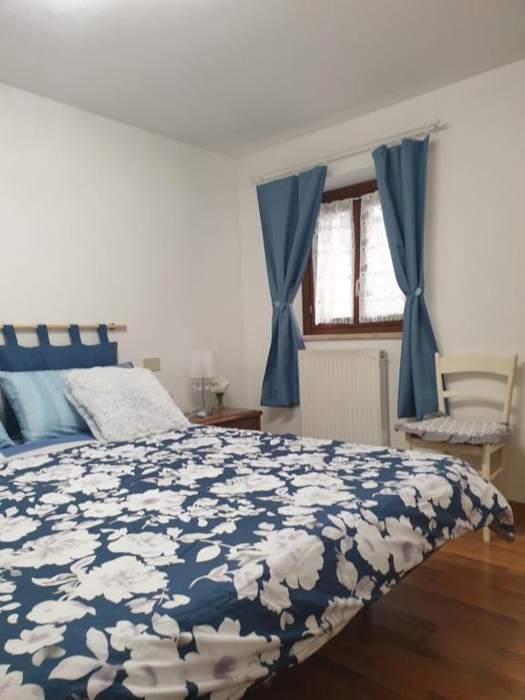 ein Schlafzimmer mit einem Bett mit einer blau-weißen Bettdecke in der Unterkunft Grazioso Appartamento, Aria Condizionata "ALLE MURA DEL CASTELLO 1 Stefano e Paola Marchesini" in Gorizia