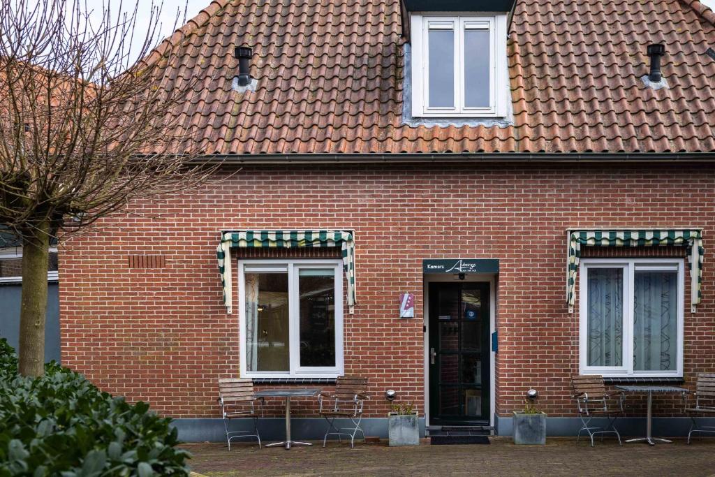 een gebouw van rode baksteen met een deur en ramen bij Cosy Hotel in Historical Center of Blokzijl in Blokzijl