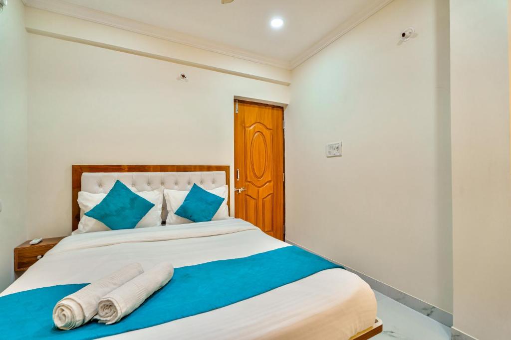 a bedroom with a large bed with blue pillows at Greenfinch Apartment in Baga
