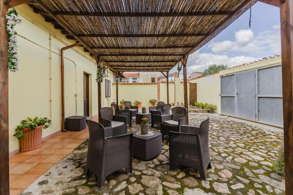 un patio avec des chaises et des tables sous une pergola dans l'établissement Il Corbezzolo, à Palmas Arborea