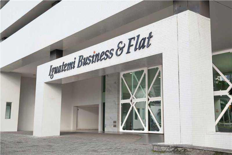 un edificio de ladrillo blanco con un cartel. en Apto Hotel Iguatemi Business Flat Corporation en Salvador