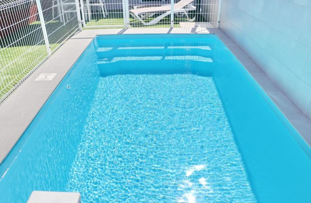 una piscina con agua azul en un edificio en Apartamento Rural Marisma, en Hozanejos
