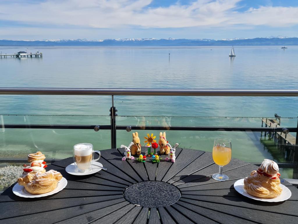 una mesa con dos platos de comida y vasos de zumo de naranja en Birkhofer See genießen - Aparthotel am Bodensee, en Immenstaad am Bodensee